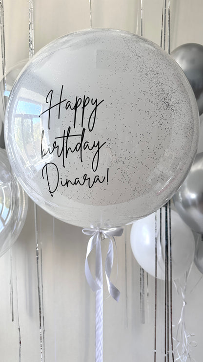 Close-up of personalized white bubble balloon with silver and white celebration balloons in Brooklyn